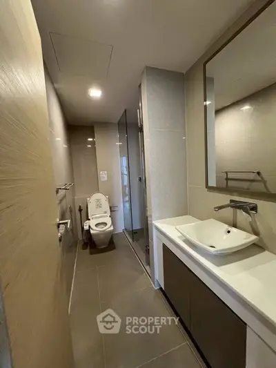 Modern bathroom with sleek fixtures and spacious layout in a contemporary apartment.