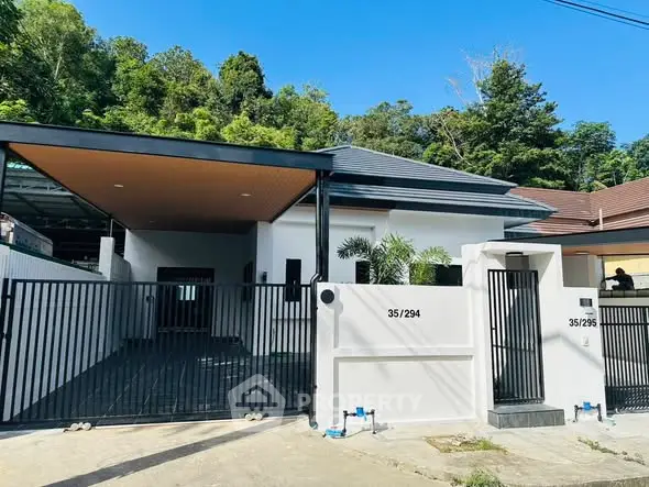 Modern single-story house with sleek design and gated entrance in a serene neighborhood.