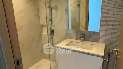 Modern bathroom with sleek shower and stylish vanity in a contemporary apartment.