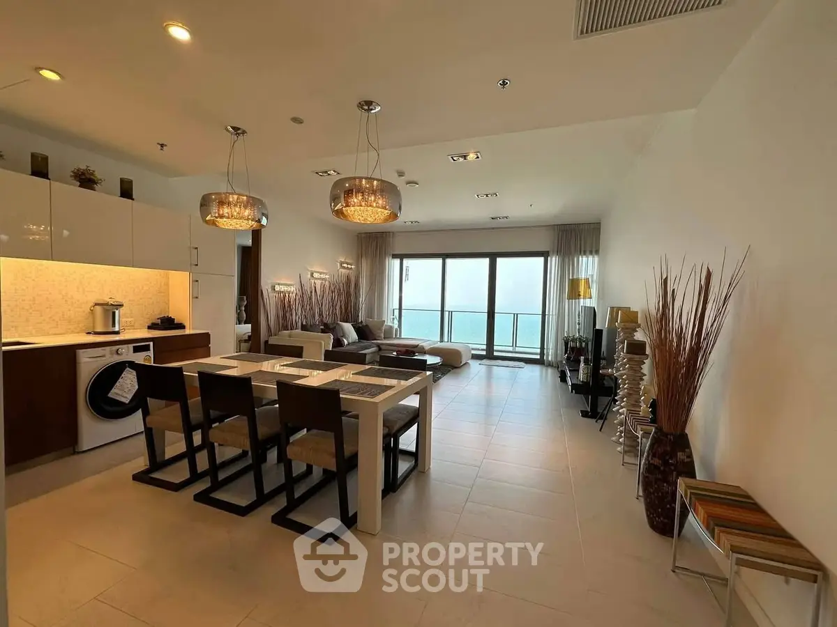 Luxurious open-plan living room with modern kitchen and stunning sea view balcony.