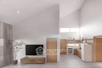 Modern open-plan living room with high ceilings and sleek kitchen appliances.
