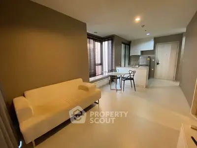 Modern open-layout living room with cozy sofa and dining area in stylish apartment.