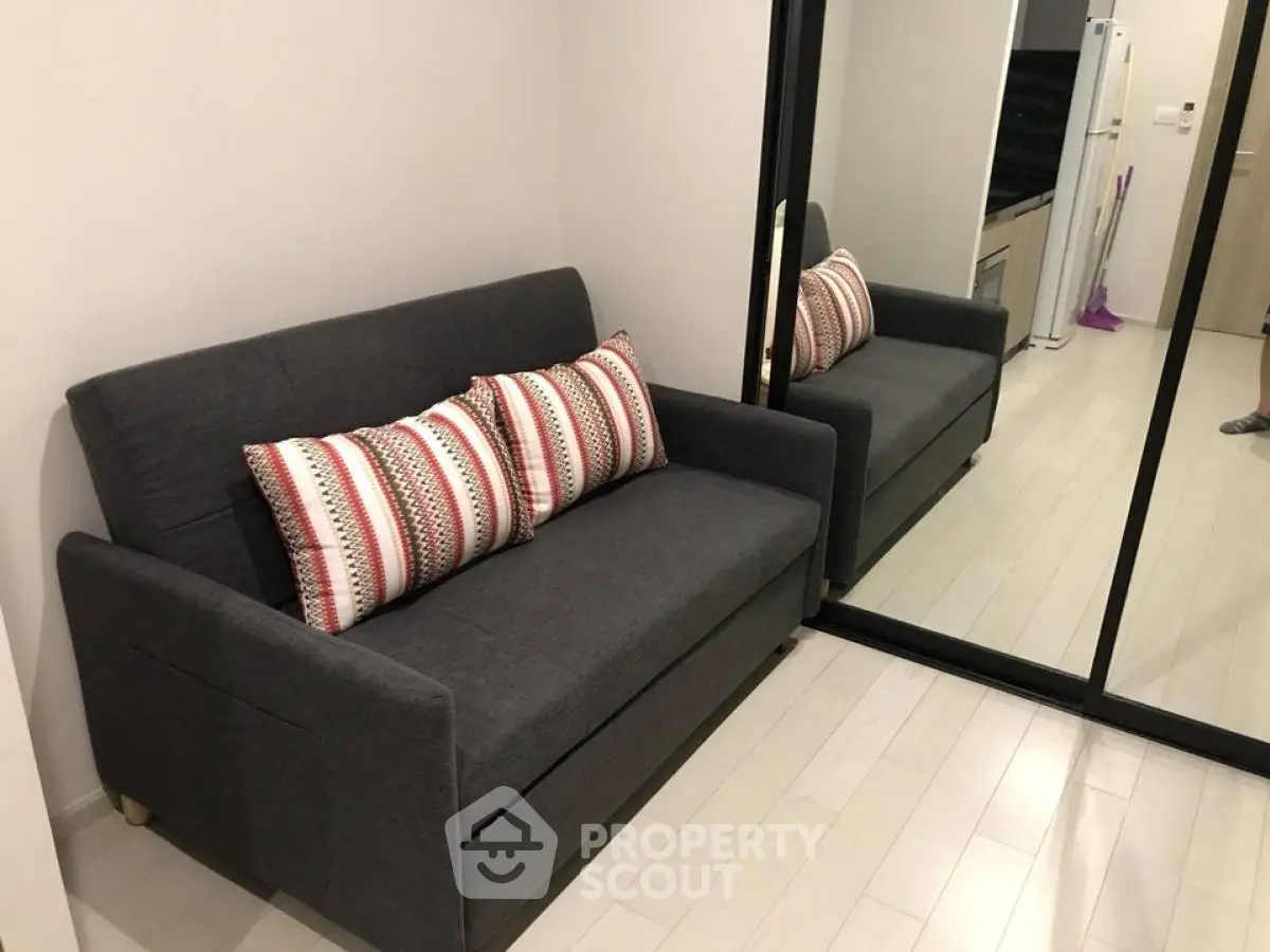 Cozy living room with modern gray sofa and mirrored closet doors