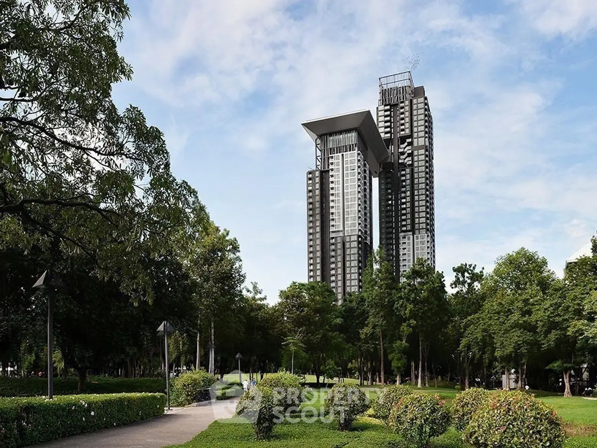 Luxurious high-rise building with modern architecture surrounded by lush greenery and scenic views.