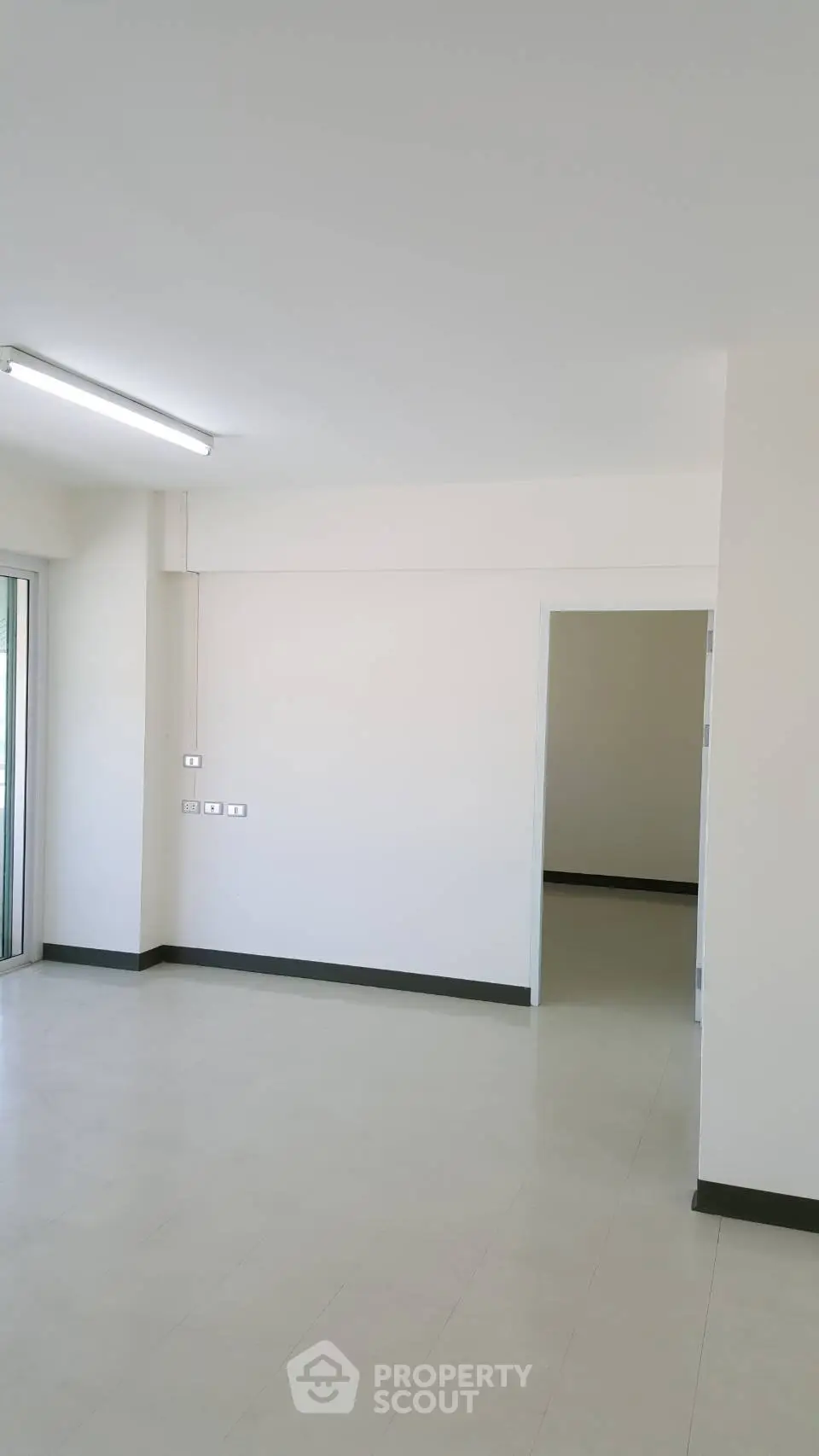 Spacious empty room with bright natural light and modern minimalist design.