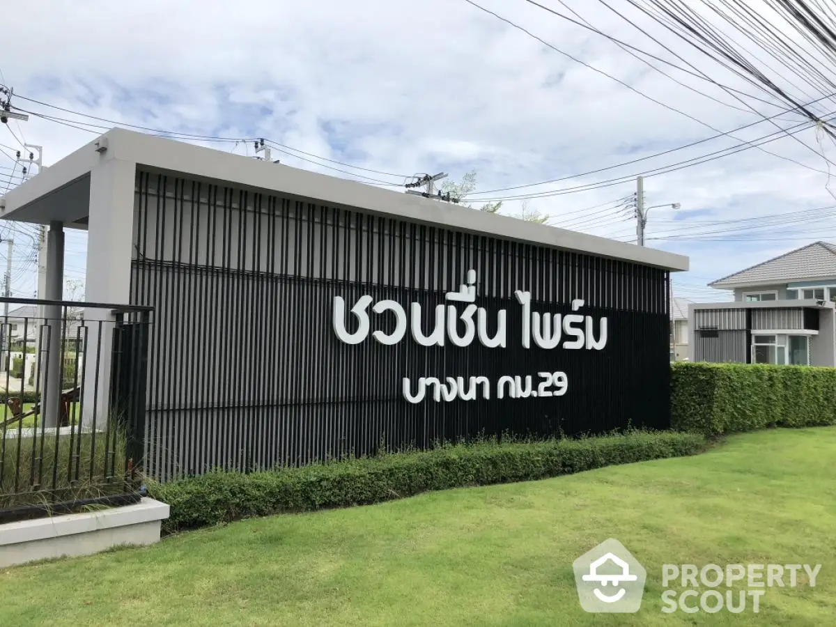 Modern residential entrance with stylish signage and lush greenery