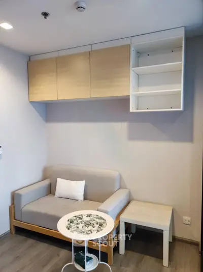 Modern living room with minimalist furniture and wall-mounted storage cabinets.