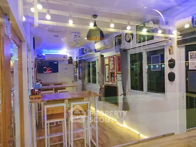 Modern interior dining area with stylish lighting and wooden tables, perfect for cozy gatherings.