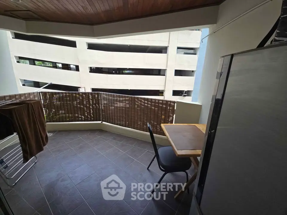 Cozy balcony with seating area and view of adjacent building