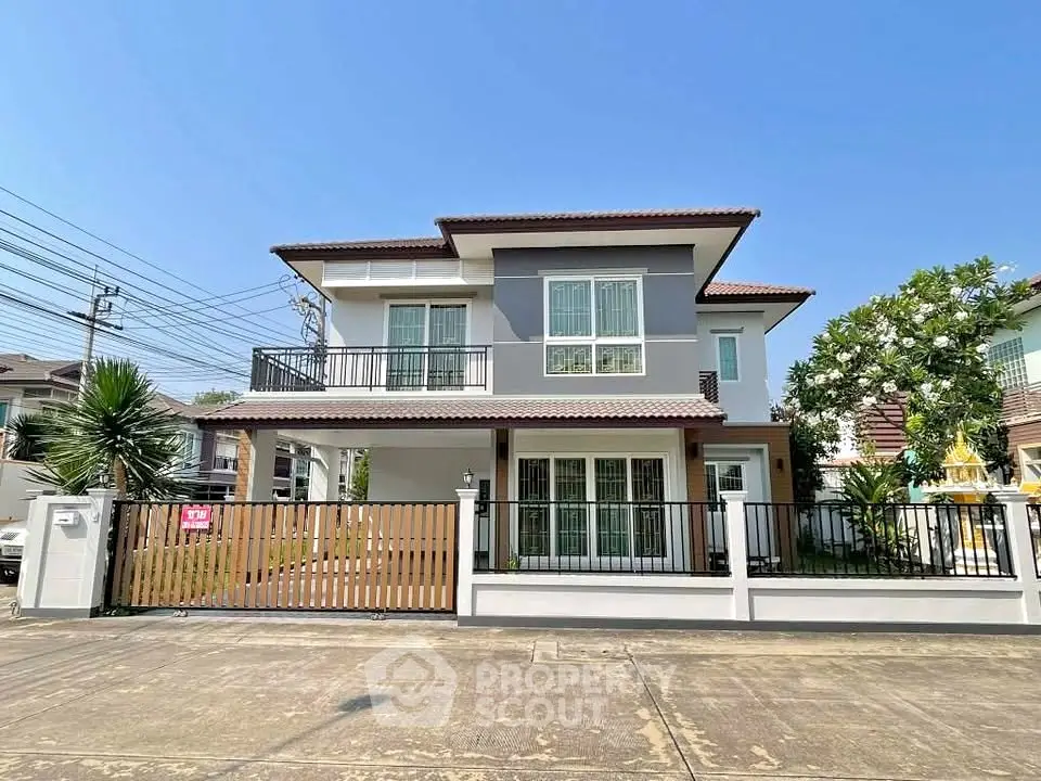Stunning two-story modern house with spacious balcony and gated entrance in a serene neighborhood.