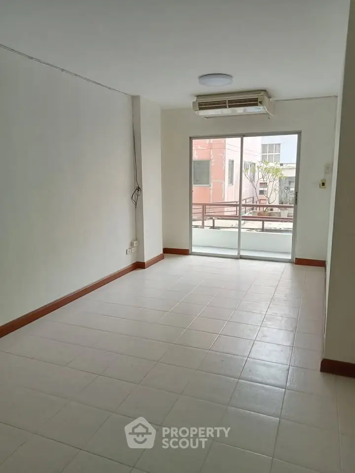 Spacious unfurnished room with large window and air conditioning, ideal for customization.