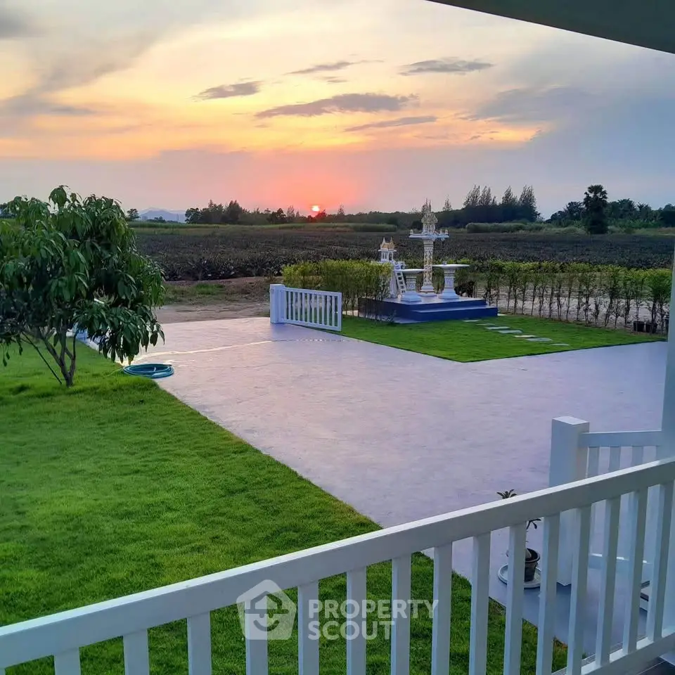 Stunning sunset view from a spacious garden with lush greenery and open space.