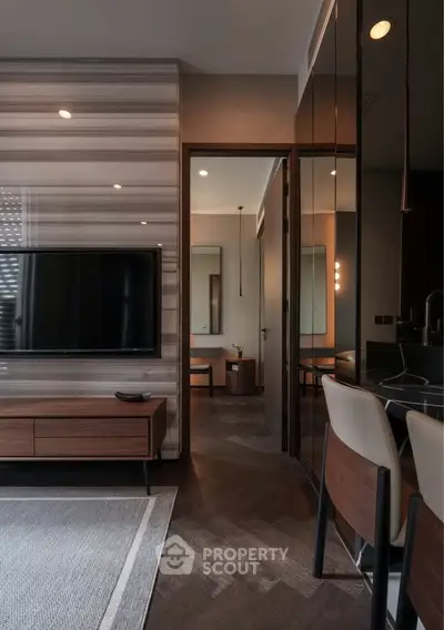 Modern living room with sleek TV setup and stylish furniture in contemporary apartment.