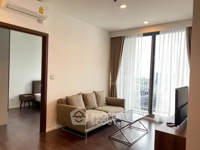 Modern living room with sleek sofa and city view through large windows.