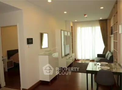 Modern living room with elegant furniture and natural light from large window.