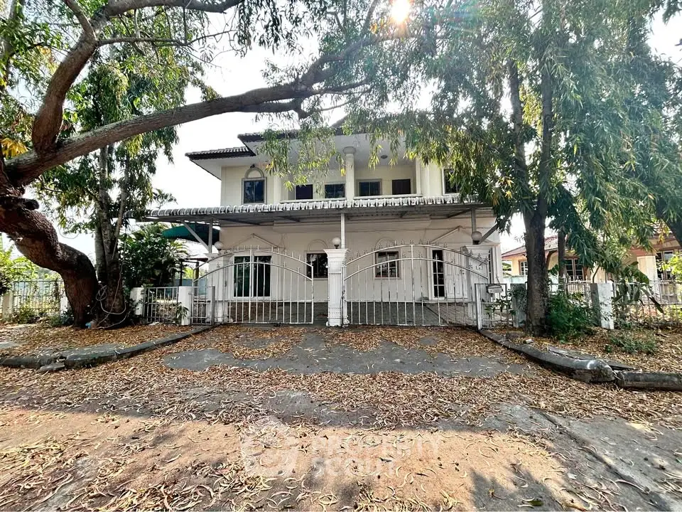 Charming two-story house with spacious front yard and mature trees, perfect for family living.