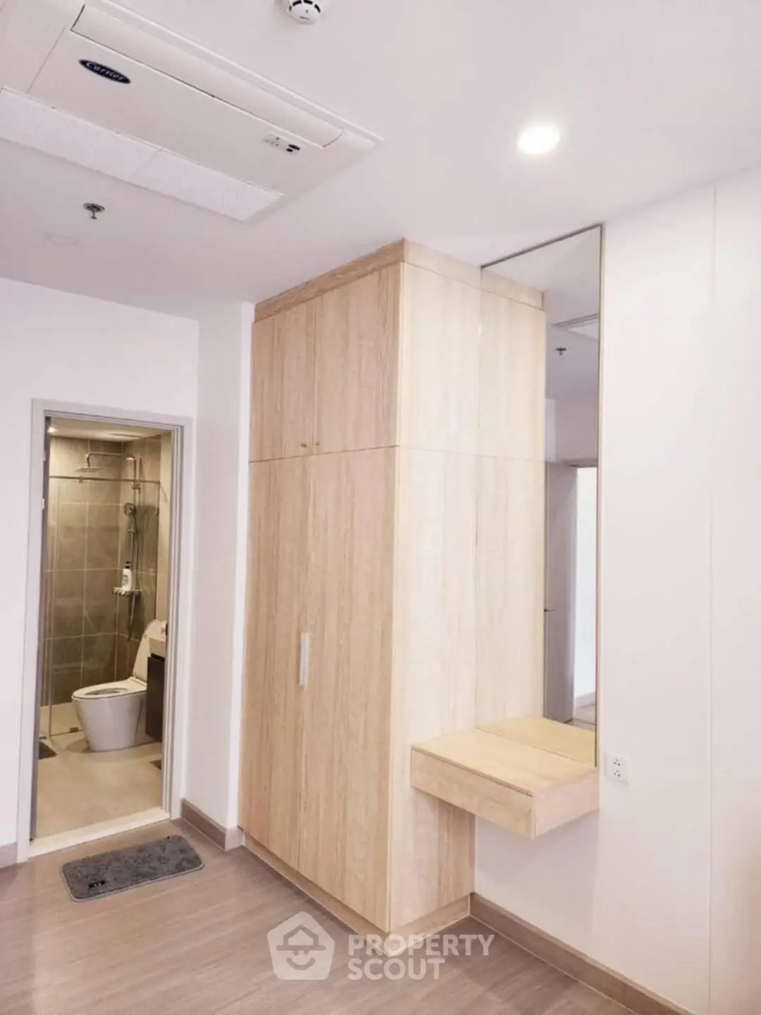 Modern apartment interior with wooden cabinetry and bathroom view