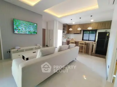 Modern open-layout living room with sleek kitchen and stylish lighting
