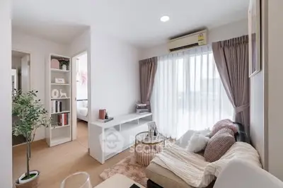 Modern living room with cozy sofa, air conditioning, and natural light from large window.