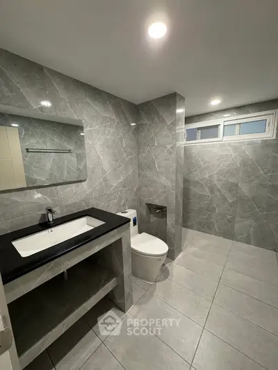 Modern bathroom with sleek gray tiles and spacious layout