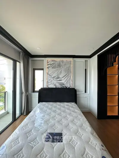 Modern bedroom with large window and stylish decor in a luxury apartment.