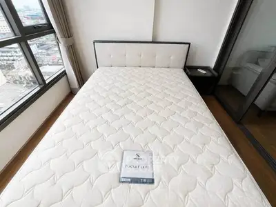 Spacious bedroom with large windows and a comfortable pocket coil mattress.