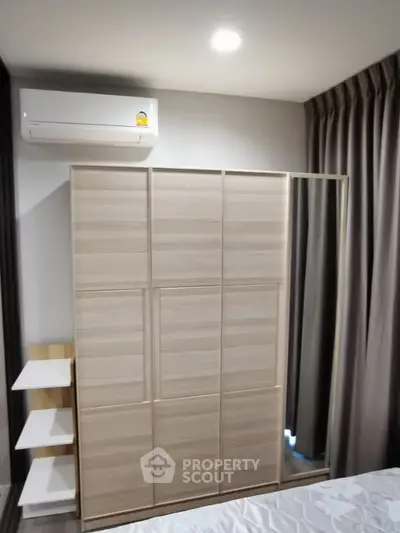 Modern bedroom with sleek wardrobe and air conditioning unit