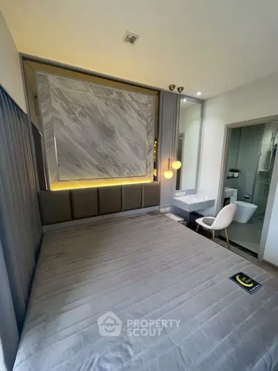 Modern bedroom with stylish decor and ensuite bathroom, featuring elegant lighting and contemporary design.