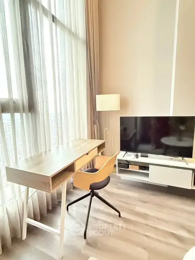 Modern living room with stylish desk and TV setup, featuring floor-to-ceiling windows for natural light.