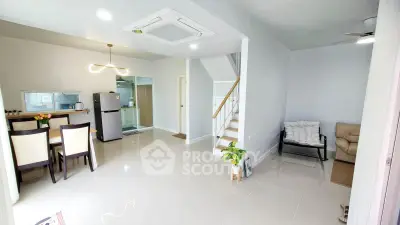 Spacious modern living room with dining area and staircase in bright open-plan layout.