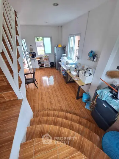 Spacious kitchen with wooden flooring and modern appliances, perfect for culinary enthusiasts.