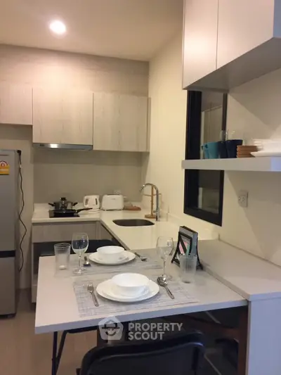 Modern kitchen with sleek cabinetry and dining setup in a cozy apartment