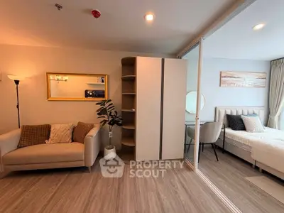 Modern studio apartment with cozy living area and stylish bedroom, featuring elegant decor and natural lighting.
