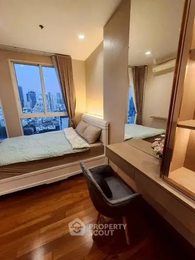 Cozy bedroom with city view, featuring a stylish bed, wooden flooring, and a chic vanity area.