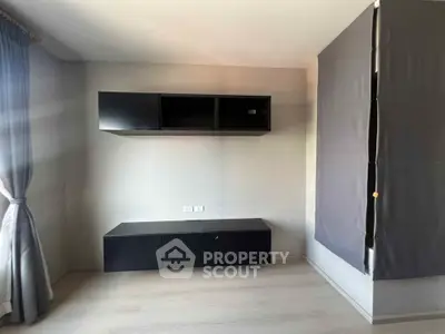 Modern minimalist living room with sleek black cabinets and natural light