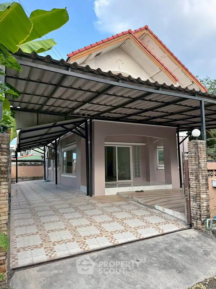 Charming single-story house with spacious carport and tiled driveway, perfect for family living.