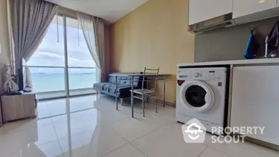 Modern apartment with ocean view, featuring washing machine and sleek interior design.