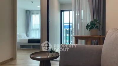 Modern apartment interior with cozy living room and view into a stylish bedroom