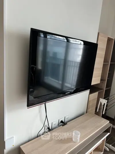 Modern living room with wall-mounted TV and stylish wooden furniture