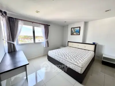 Spacious bedroom with large window offering a scenic view, modern furnishings, and ample natural light.
