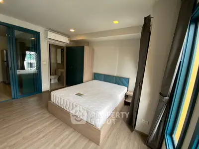 Modern bedroom with stylish decor and large windows in a contemporary apartment.