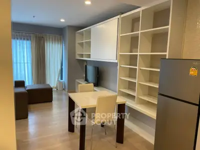 Modern living room with open kitchen and stylish shelving in a cozy apartment.