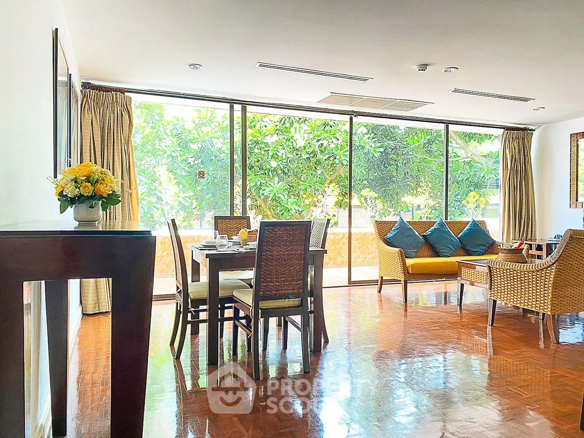 Spacious living room with large windows and elegant decor, perfect for relaxation and entertaining.