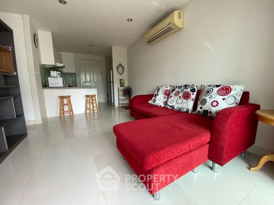 Spacious living room with modern red sofa and open kitchen layout
