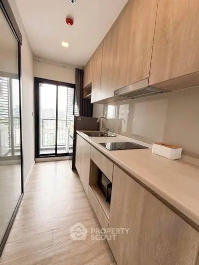 Modern kitchen with sleek wooden cabinets and city view balcony
