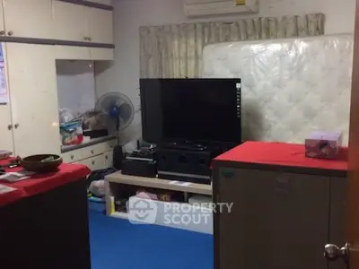 Cozy living room with TV, storage, and air conditioning in compact space.