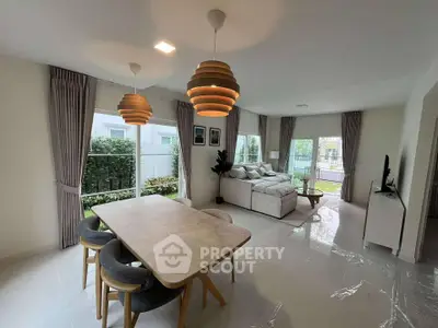 Spacious modern living room with dining area and large windows overlooking garden