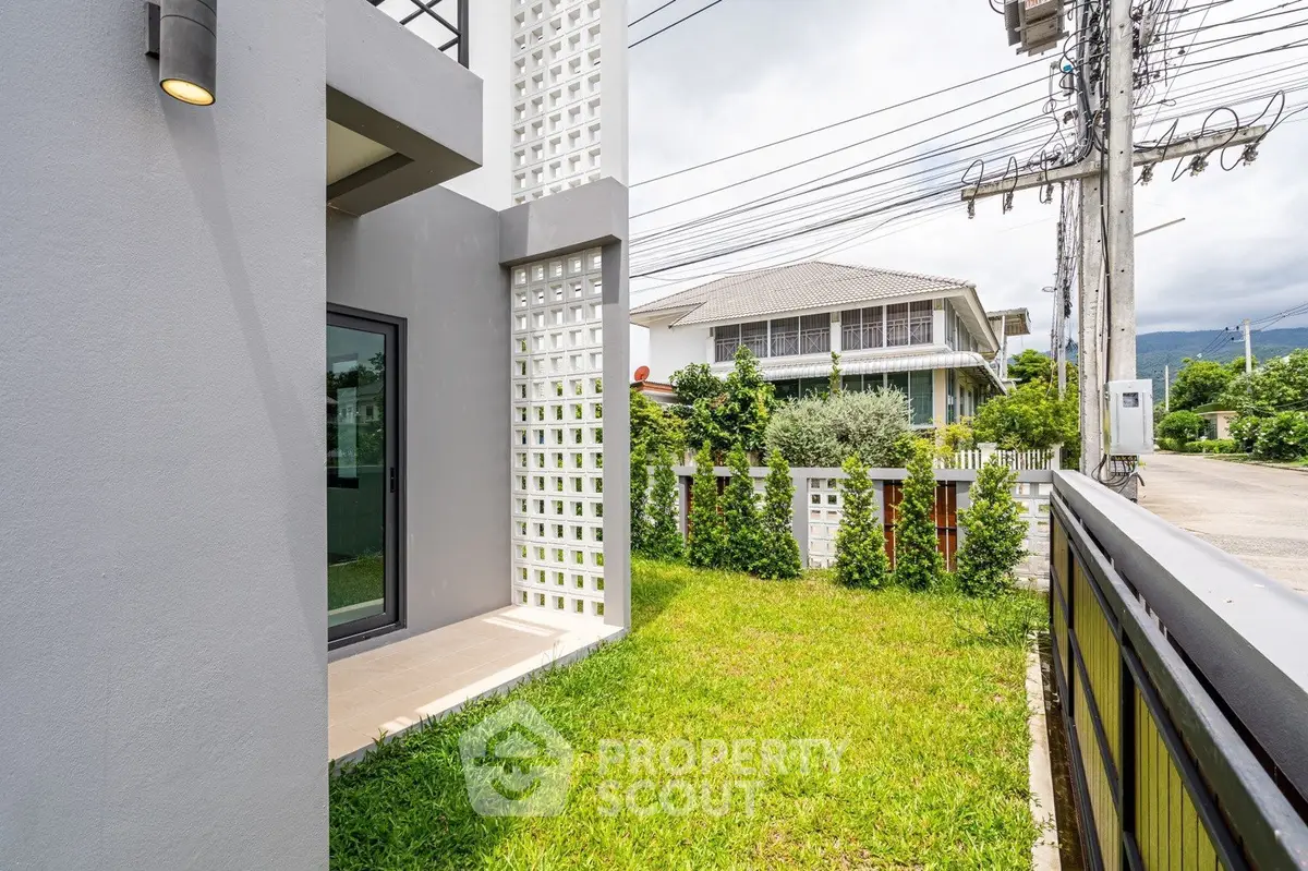 Modern house exterior with lush green lawn and contemporary design elements.