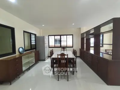 Spacious dining area with elegant wooden furniture and large windows for natural light.