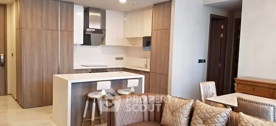 Modern open-layout kitchen and living room with stylish furniture and neutral tones.